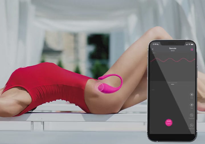 Mujer acostada con el Lovense Lush 3 mientras la app cambia la vibración en el celular